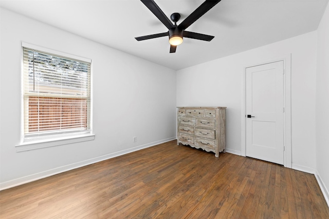 spare room featuring wood finished floors, baseboards, and a ceiling fan