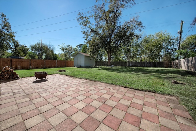 view of patio with an outbuilding, a fenced backyard, and a shed