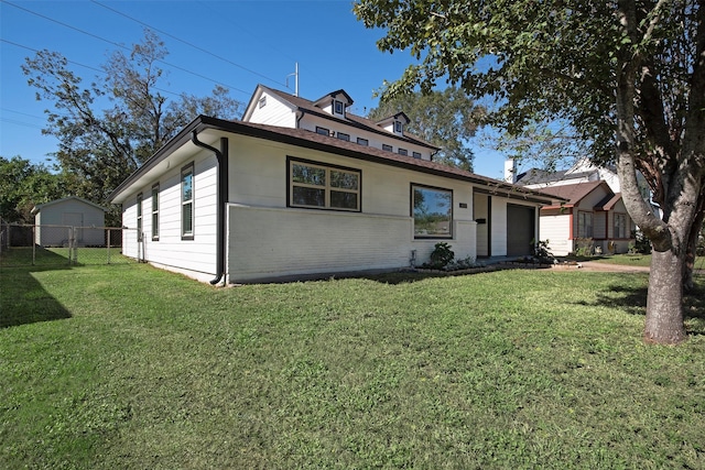 view of front of home featuring a front lawn, fence, and an attached garage
