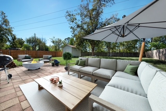 view of patio / terrace with an outdoor living space with a fire pit, a fenced backyard, a storage unit, and an outdoor structure