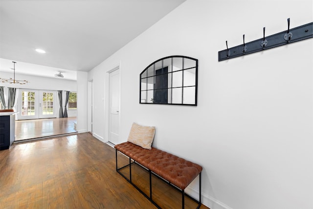 hall with baseboards, dark wood-style flooring, a chandelier, recessed lighting, and french doors