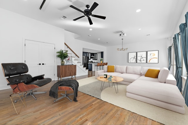 living area with recessed lighting, light wood-style flooring, stairs, visible vents, and ceiling fan with notable chandelier