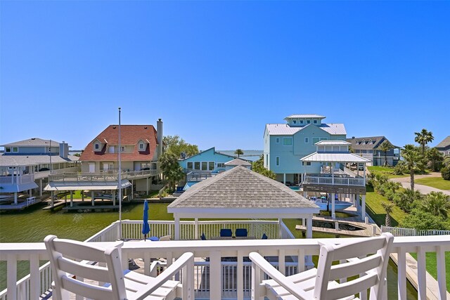 view of dock featuring a gazebo, a residential view, and a water view
