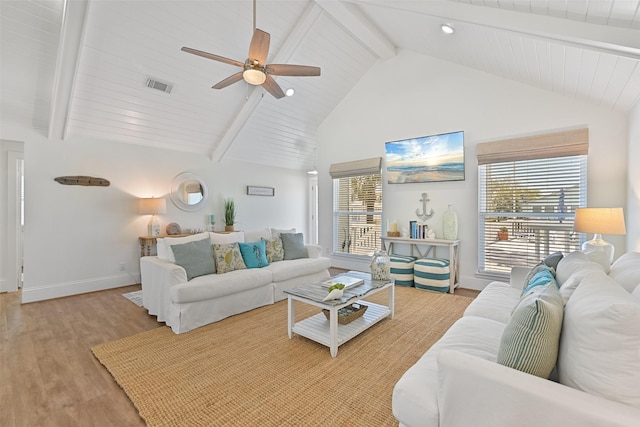living area featuring a healthy amount of sunlight, visible vents, wood finished floors, and ceiling fan