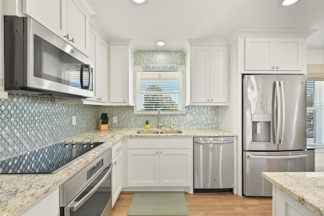 kitchen with white cabinets, a wealth of natural light, a sink, and appliances with stainless steel finishes