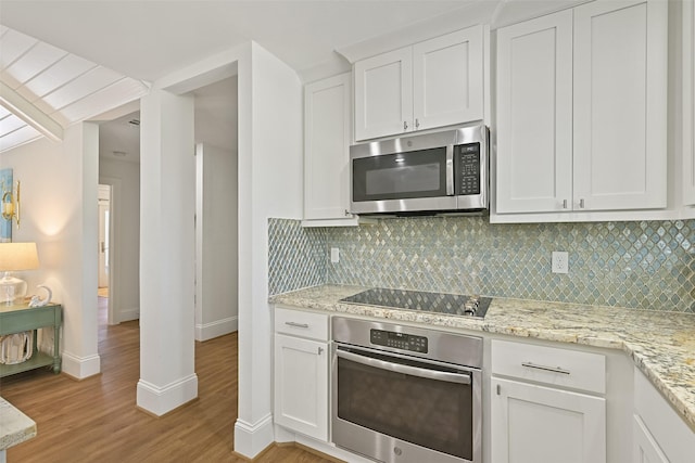 kitchen featuring light wood-style flooring, white cabinetry, decorative backsplash, and appliances with stainless steel finishes