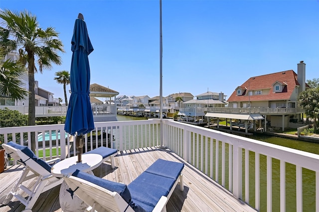 wooden terrace featuring a water view and a residential view