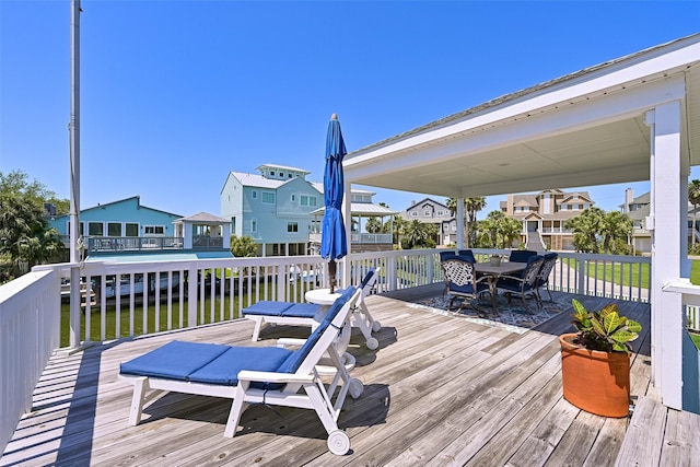 wooden deck featuring outdoor dining space and a residential view