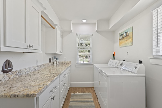 laundry room with baseboards, independent washer and dryer, wood finished floors, and cabinet space
