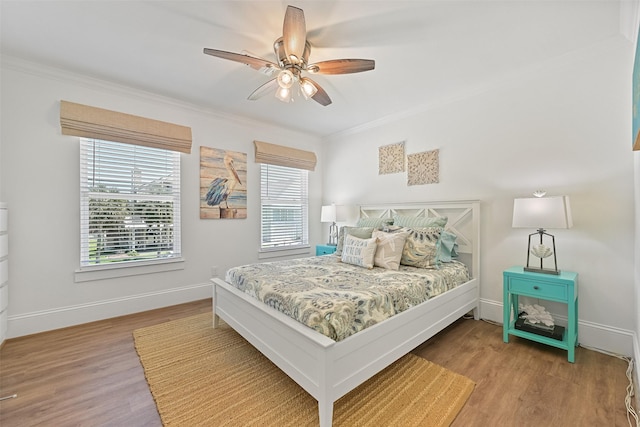 bedroom featuring baseboards, crown molding, and wood finished floors
