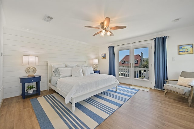bedroom featuring crown molding, visible vents, access to outside, and wood finished floors