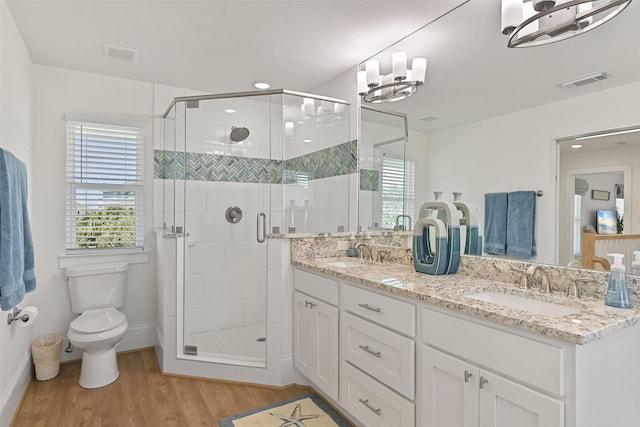 bathroom with visible vents, a sink, toilet, and wood finished floors