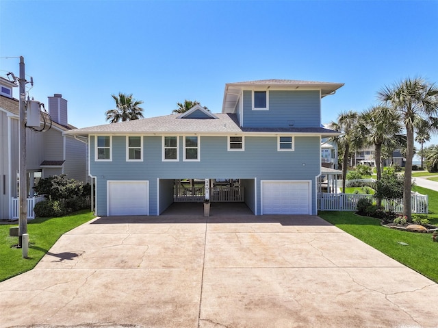 view of front of property with a garage, driveway, fence, and a front lawn