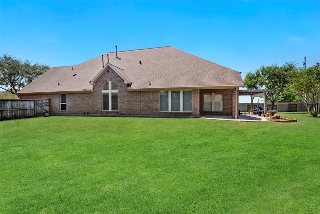 rear view of property with brick siding, a yard, a patio area, and roof with shingles