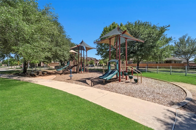 community playground featuring a lawn and fence