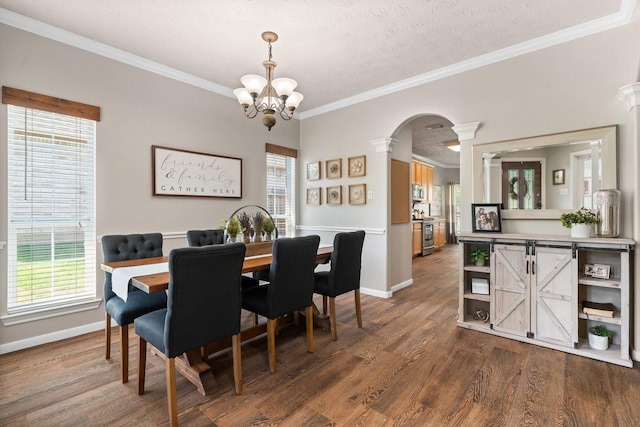 11926 Brightwood Dr, Montgomery, TX 77356 - dining room featuring a notable chandelier, baseboards, dark wood-style flooring, crown molding, and arched walkways
