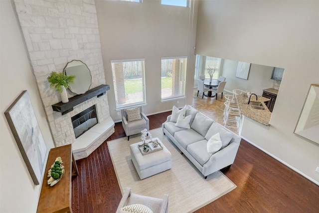 3315 Brampton Island Dr, Katy, TX 77494 - living area featuring a high ceiling, wood finished floors, a fireplace, and baseboards
