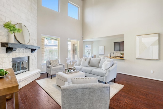 3315 Brampton Island Dr, Katy, TX 77494 - living area featuring dark wood-style flooring, a stone fireplace, and baseboards