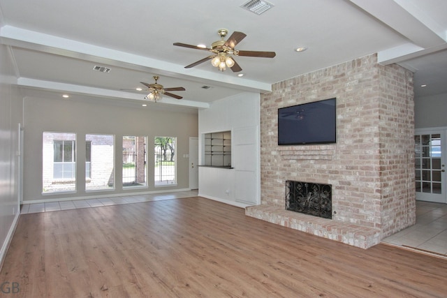 unfurnished living room with wood finished floors, beamed ceiling, and visible vents