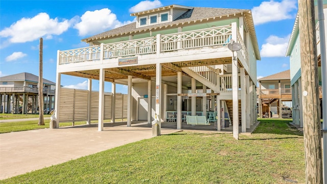1979 Matt Dr, Crystal Beach, TX 77650 - back of property featuring concrete driveway, a carport, a lawn, a shingled roof, and a deck