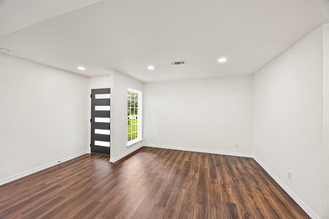 spare room featuring baseboards, dark wood-style flooring, visible vents, and recessed lighting