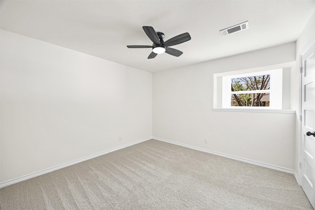 carpeted spare room with baseboards, visible vents, and ceiling fan