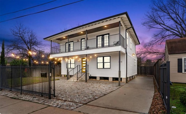 view of front facade with a balcony and fence private yard