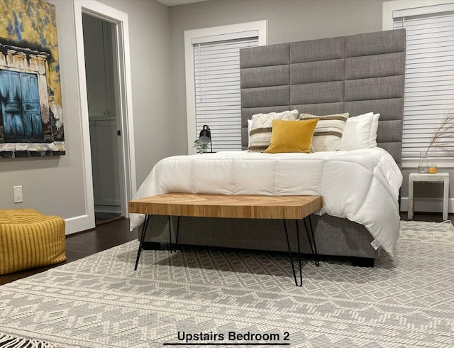 bedroom with baseboards and wood finished floors