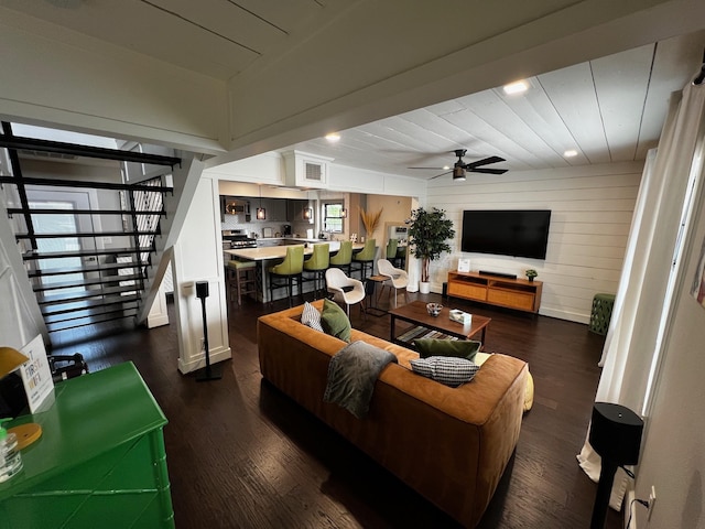 living area featuring stairs, a ceiling fan, dark wood-style floors, and visible vents
