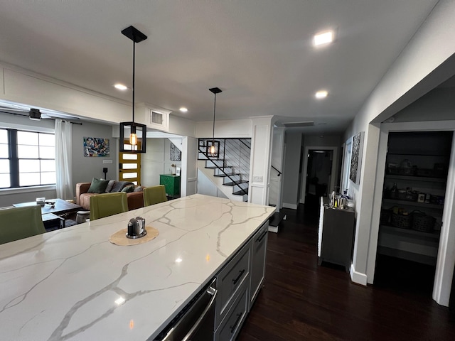 kitchen featuring light stone counters, hanging light fixtures, baseboards, dark wood-type flooring, and recessed lighting