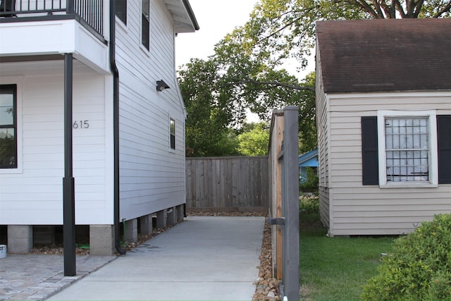 view of side of home with a balcony and fence