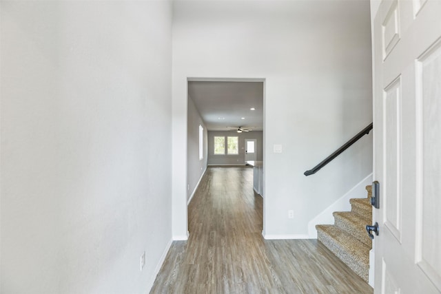 foyer featuring wood finished floors, stairs, baseboards, ceiling fan, and recessed lighting