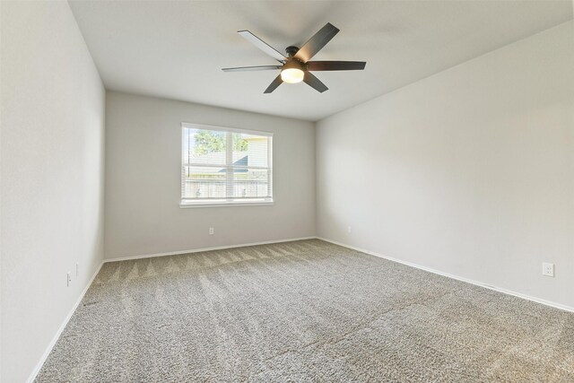 empty room featuring a ceiling fan, carpet, and baseboards