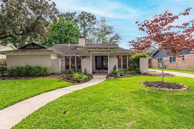 single story home featuring a chimney, a gate, a fenced front yard, a front lawn, and brick siding