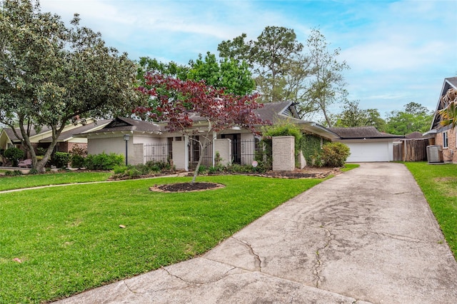 view of front facade featuring central AC, a front lawn, fence, and driveway
