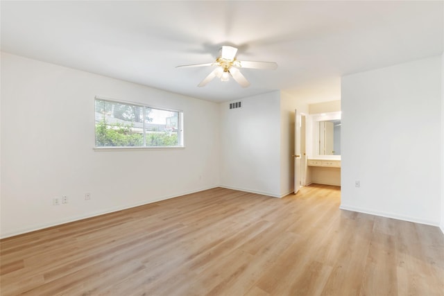 unfurnished room with light wood finished floors, baseboards, visible vents, and ceiling fan