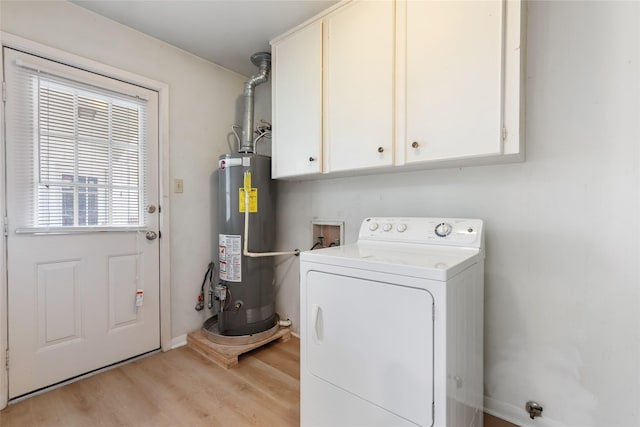 laundry area featuring water heater, washer / dryer, cabinet space, light wood-style flooring, and baseboards