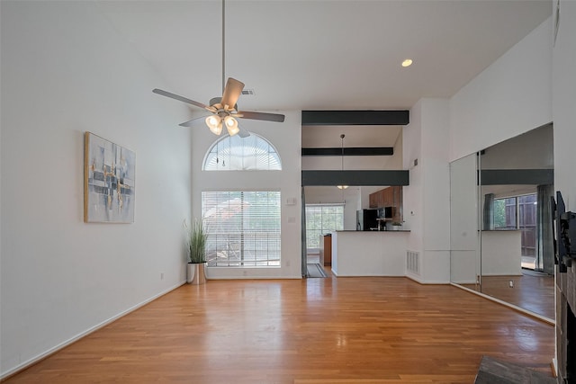 1904 Portsmouth St, Houston, TX 77098 - unfurnished living room featuring visible vents, high vaulted ceiling, light wood-style floors, and a ceiling fan