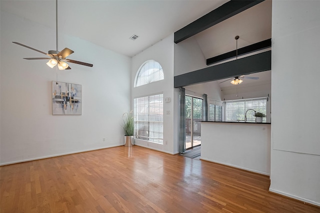 1904 Portsmouth St, Houston, TX 77098 - unfurnished living room with visible vents, a sink, ceiling fan, beam ceiling, and wood finished floors