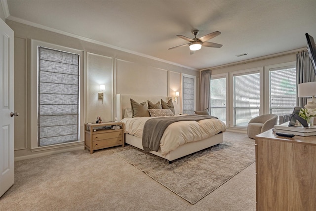 bedroom with ornamental molding, light carpet, a decorative wall, and a ceiling fan