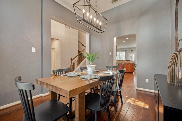 dining space with stairway, dark wood finished floors, baseboards, and a high ceiling