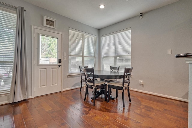 dining space featuring baseboards, wood finished floors, and recessed lighting