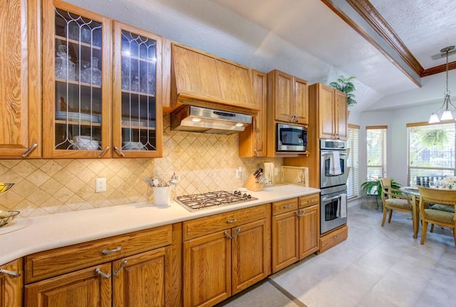 kitchen featuring stainless steel appliances, vaulted ceiling, exhaust hood, and decorative backsplash
