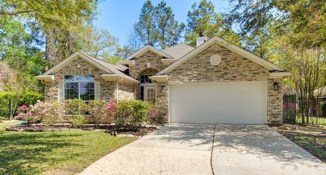 24501 Sable Creek Ct, Porter, TX 77365 - view of front of home with stone siding, a garage, concrete driveway, and a chimney
