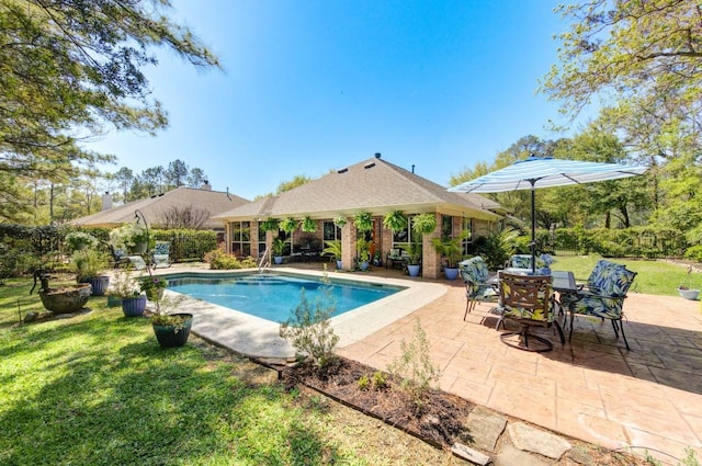 pool with a patio area and a yard