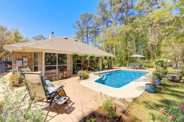 view of swimming pool featuring fence and a patio