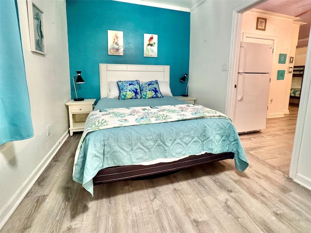 101 Saltgrass Ave, Surfside Beach, TX 77541 - bedroom with baseboards, freestanding refrigerator, and wood finished floors