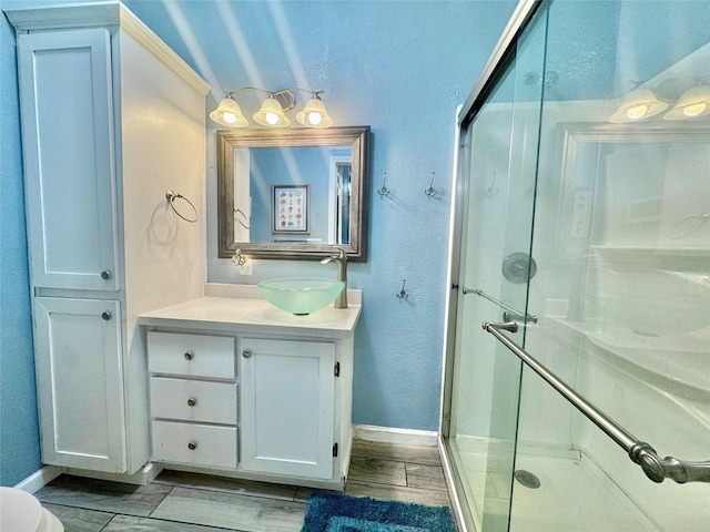 101 Saltgrass Ave, Surfside Beach, TX 77541 - bathroom with vanity, baseboards, a stall shower, and wood finished floors
