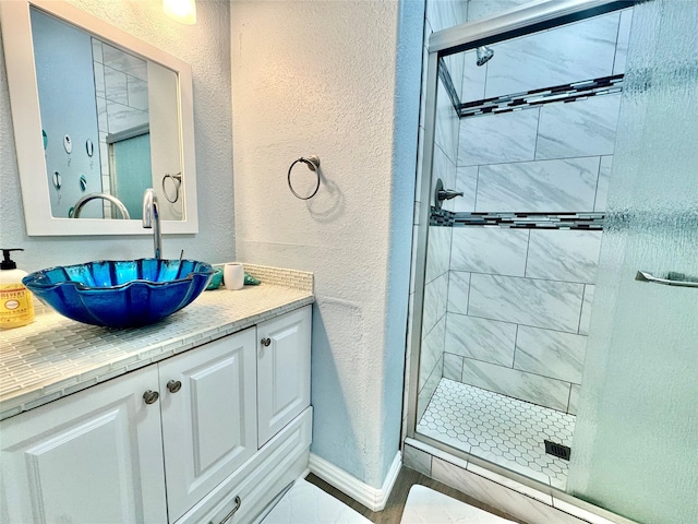 101 Saltgrass Ave, Surfside Beach, TX 77541 - bathroom with a textured wall, vanity, baseboards, and a stall shower