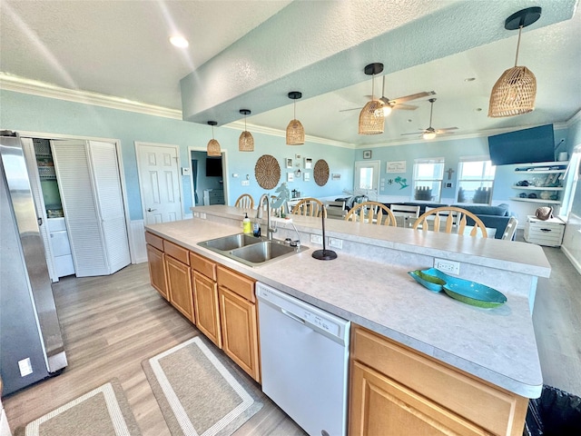 101 Saltgrass Ave, Surfside Beach, TX 77541 - kitchen featuring freestanding refrigerator, crown molding, light wood finished floors, dishwasher, and a sink